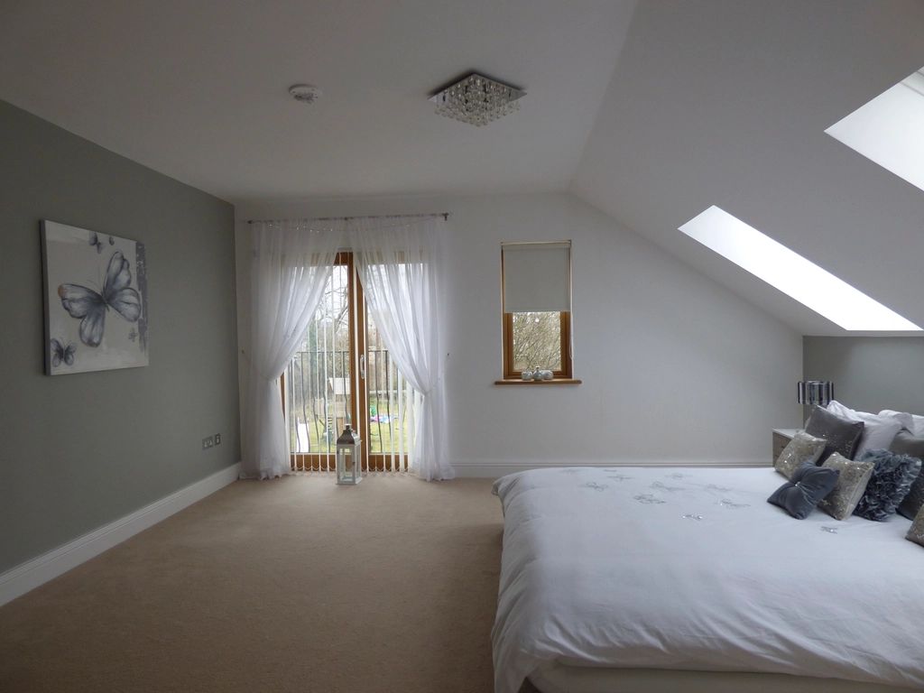 A guest room with a large bed and soft lighting